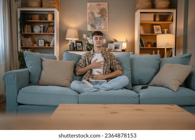 one teenager man young caucasian male use headphones for online guided meditation practice mindfulness yoga with eyes closed at home real people self care manifestation concept copy space generation Z - Shutterstock ID 2364878153