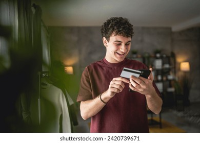 One teenager young man caucasian male sit at home use credit card shopping online use internet for online purchase active modern e-banking - Powered by Shutterstock