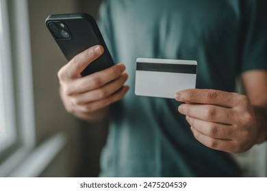 One teenager young man caucasian male sit at home use credit card and laptop computer shopping online use internet for online purchase active modern e-banking hold mobile phone and credit card - Powered by Shutterstock