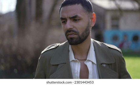 One thoughtful young Middle Eastern man standing outside at park thinking. Closeup face of a pensive Arab male person - Shutterstock ID 2301443453