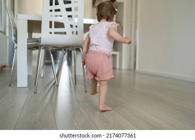 One Toddler Running And Playing At Home In The Living Room Back View Early Child Development And Learning Concept Small Caucasian Baby Girl Walking In Apartment Alone Full Length Copy Space