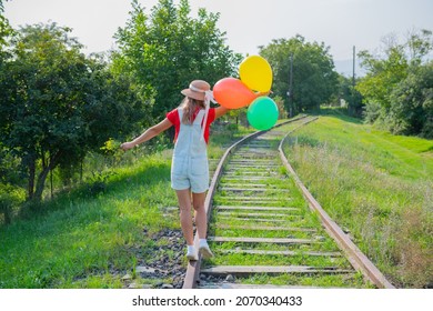 one tourist walks with colored balloons on the railway. High quality photo - Powered by Shutterstock