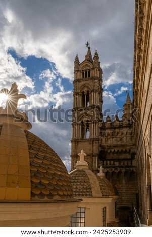 one of the two bell towers and rooftop with cupolas of the Palermo Cathedral with a sunburst