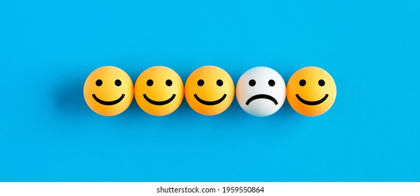 One Unhappy Face Emoticon Among Happy Face Emojis In A Row. Customer Dissatisfaction Or Unhappy Client Concept.