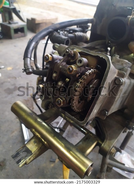 one unit of a motorcycle engine that is being\
serviced at a motorcycle repair\
shop
