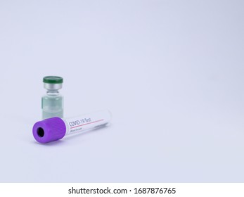 One Vaccine Vial And An Empty Blood Sample Tube On White Background For Corona Virus Test And Cure.