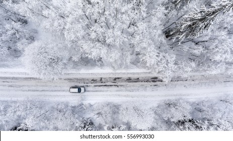 One Vehicle Driving Through The Winter Snowy Forest On Country Road. Top View