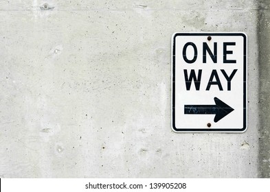 One Way Sign And Arrow On Concrete