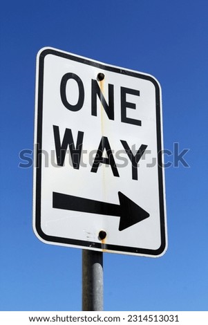 One way street road sign against a blue sky background