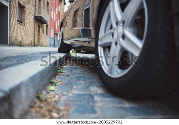 one wheel on\
curb, bad parking on a\
sidewalk