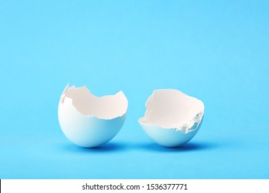 One White Broken Egg Shell On Blue Background. Breaking Out Of The Shell