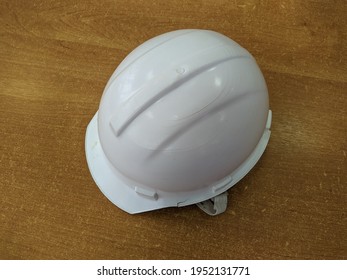 One White Hard Hat On Wooden Background Close Up Photo