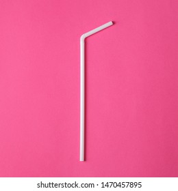 One white plastic straw on pink background. Plastic pollution. Environmental concept