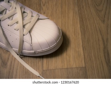 One White Sneaker With Untied Laces