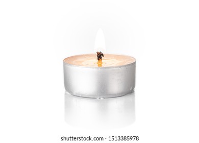One whole burning waxy white tea candle isolated on white background