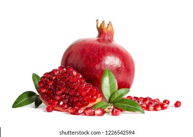 one whole and part of a pomegranate with pomegranate seeds and leaves isolated on white background