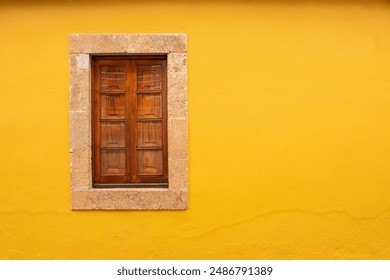 One window with closed wooden shutters, stone window frame and yellow wall. Stone house. Historic village Gran Canaria detail. Urban background. European architecture.  - Powered by Shutterstock