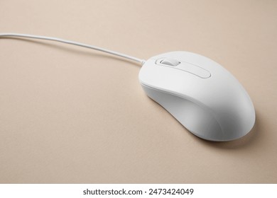One wired mouse on beige background, closeup