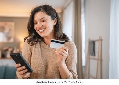 One woman adult caucasian female at home happy smile hold bank credit card and digital tablet online shopping e-banking concept real people copy space e-commerce make purchase or booking reservation - Powered by Shutterstock