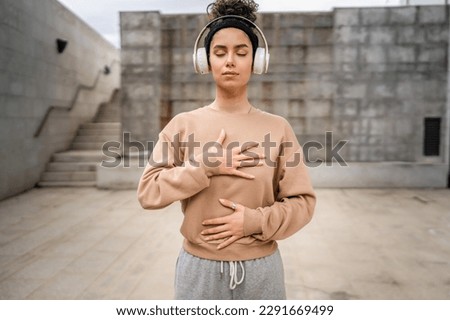one woman adult caucasian female using headphones for online guided meditation practicing mindfulness manifestation with eyes closed stand outdoor real people self care concept copy space