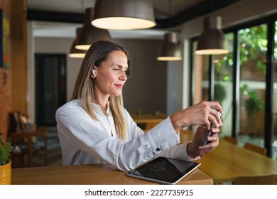 One woman adult middle age caucasian female standing at work happy smile confident wear white shirt waist up copy space front view portrait using mobile phone making a call or send sms confident - Shutterstock ID 2227735915