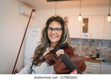 One woman caucasian indoor in her house holding violin and learning to play front view waist up Study from home lifestyle concept - Powered by Shutterstock