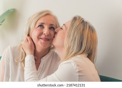 One Woman Kissing The Other On A Cheek Closeup Living Room Female Couple. High Quality Photo