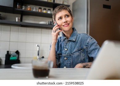 One woman mature caucasian female using mobile phone in the kitchen in the morning daily routine real people leisure and relaxation concept copy space making a call talking happy smile - Powered by Shutterstock