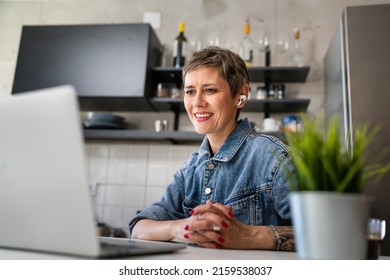 One Woman Mature Caucasian Female Working On Her Laptop Computer In The Kitchen At Home Freelance Remote Work Morning Routine Real People Copy Space Happy Smile Making Video Conference Call