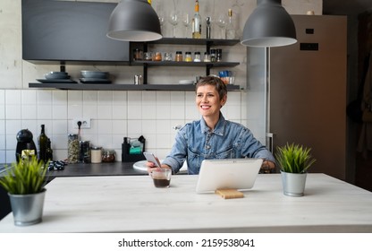 One Woman Mature Caucasian Female Having A Cup Of Coffee In The Kitchen While Using Digital Tablet Daily Morning Routine Checking Mail Or Daily Tasks While Preparing For Work Real People Copy Space