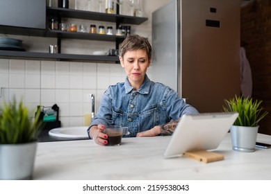 One Woman Mature Caucasian Female Having A Cup Of Coffee In The Kitchen While Using Digital Tablet Daily Morning Routine Checking Mail Or Daily Tasks While Preparing For Work Real People Copy Space