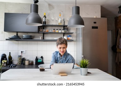 One Woman Mature Caucasian Female Having A Cup Of Coffee In The Kitchen While Using Digital Tablet Daily Morning Routine Checking Mail Or Daily Tasks While Preparing For Work Real People Copy Space