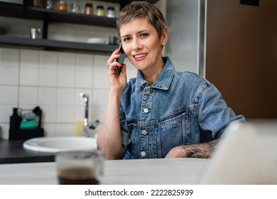 One Woman Mature Caucasian Female Using Mobile Phone In The Kitchen In The Morning Daily Routine Real People Leisure And Relaxation Concept Copy Space Making A Call Talking Happy Smile