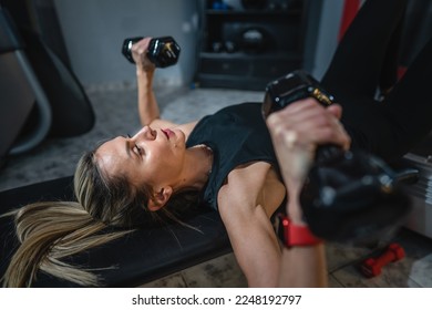 One woman mature caucasian female slim hands hold dumbbell while training at home or fitness center real people healthy lifestyle concept copy space - Powered by Shutterstock