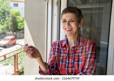 One Woman Mature Or Senior Female Smoking Cigarette By The Window At Home In Bright Day Real People Copy Space Daily Routine Unhealthy Habit Nicotine Addiction Smile Happy