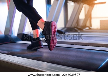 One woman running on a tread mill close up shot to the feet.