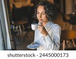 One woman stand at the window at home or office businesswoman entrepreneur wear white shirt having cup of coffee happy smile real people copy space morning routine mature caucasian female