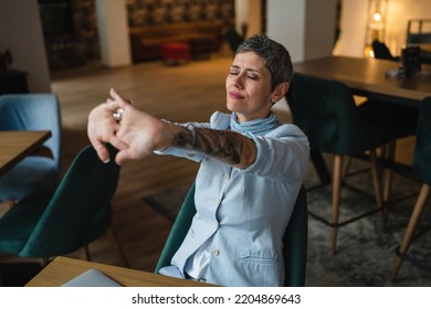 One Woman Stretching While Sit At Cafe At The Table With Laptop Computer Taking A Brake Stretching Arms And Back Sore Neck Pain Relief Business Yoga Concept Real People Candid Photo Copy Space