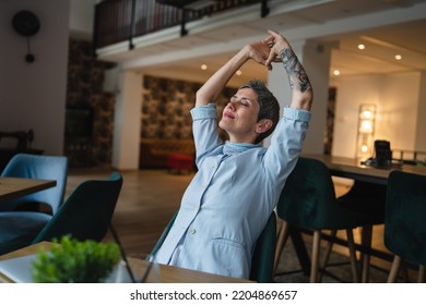 One Woman Stretching While Sit At Cafe At The Table With Laptop Computer Taking A Brake Stretching Arms And Back Sore Neck Pain Relief Business Yoga Concept Real People Candid Photo Copy Space