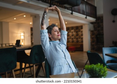 One Woman Stretching While Sit At Cafe At The Table With Laptop Computer Taking A Brake Stretching Arms And Back Sore Neck Pain Relief Business Yoga Concept Real People Candid Photo Copy Space