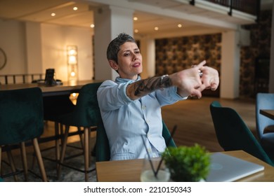 One Woman Stretching While Sit At Cafe At The Table With Laptop Computer Taking A Brake Stretching Arms And Back Sore Neck Pain Relief Business Yoga Concept Real People Candid Photo Copy Space