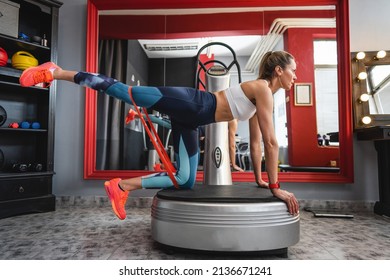 One woman training on the power plate machine female use powerplate for exercise side view full length