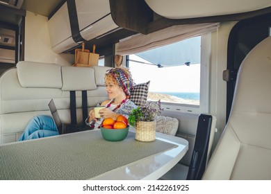 One Woman Using Laptop Inside A Modern Camper Van. Van Life And Digital Nomad Remote Worker Female People Lifestyle. Online Job Business In Alternative Caravan Office. Travel Wanderlust