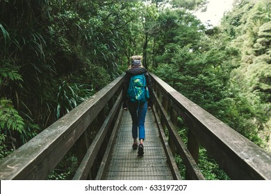 One Woman Walking On A Bridge With Backpack Traveling Alone