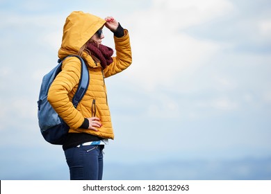 One woman with winter jacket and scarf doing outdoors recreation.