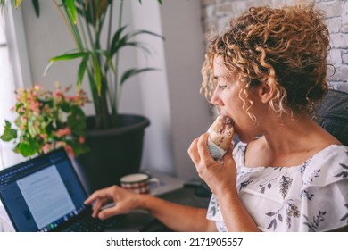 One Woman Working On Laptop And Eating A Sandwich For Lunch Break Time. Modern People Work On Computer At Home. Alternative Office And Digital Online Job Concept. Fast Food Nutrition Concept Lifestyle