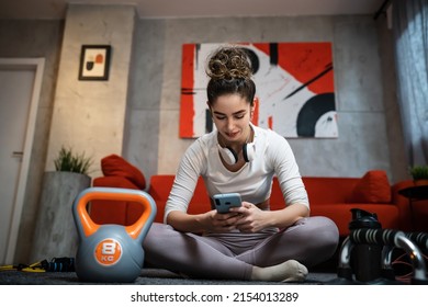 One Woman Young Adult Caucasian Female Sporty Holding Mobile Phone Using Internet For Online Training At Home Real People Sport Health And Fitness Concept Copy Space