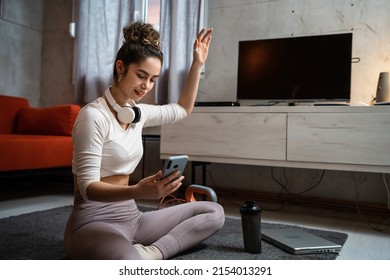 One Woman Young Adult Caucasian Female Sporty Holding Mobile Phone Using Internet For Online Training At Home Real People Sport Health And Fitness Concept Copy Space