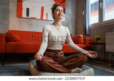 One woman young adult caucasian female sit at home on the floor practice yoga or meditate self care concept manifestation and stress relief calmness real people copy space