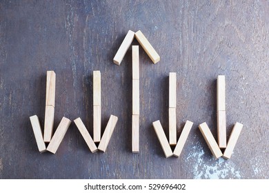 One Wood Block Arrow Is Going Up From Other Four Wood Block Arrows Are Going Down,  Present Business Success Concept.